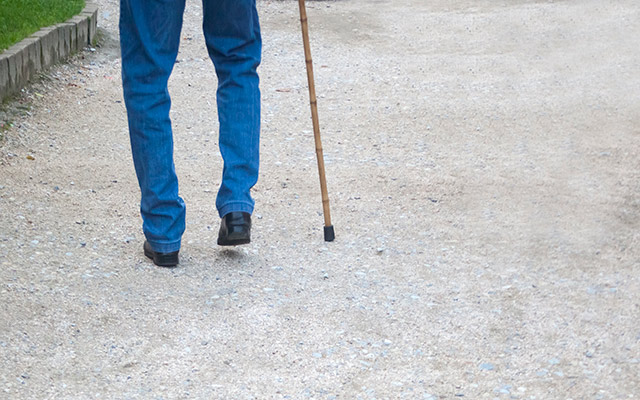 A person walks with a cane.