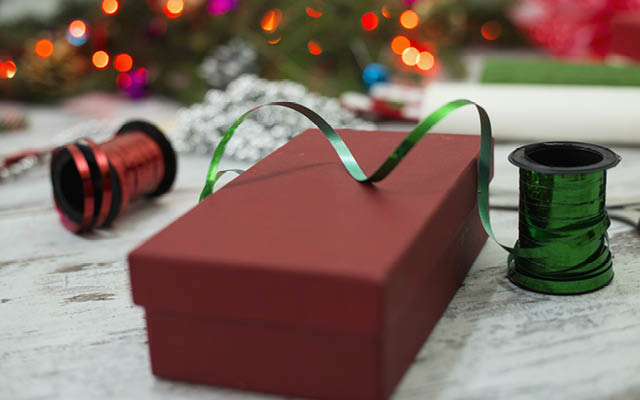 A rectangular red box is surrounded by Christmas ribbons.