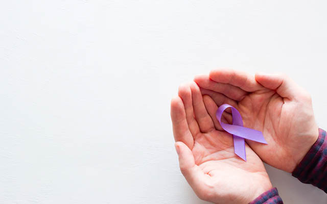 hands-hold-a-purple-ribbon