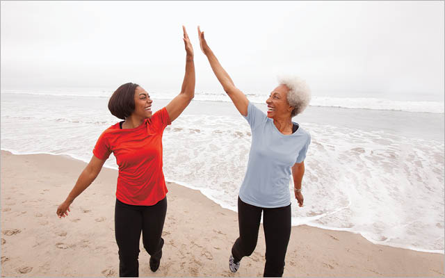 Two women giving high-five on beach