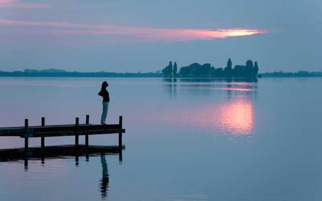 woman on dock at sunset