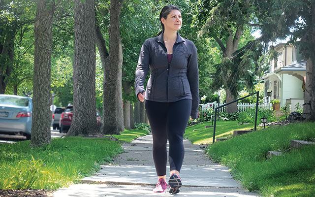 Experience Life fitness editor Maggie Fazeli Fard walks on a sidewalk.