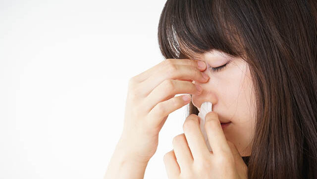 Woman stopping nosebleed