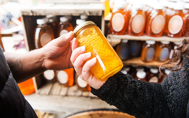 Person buying jar of honey.