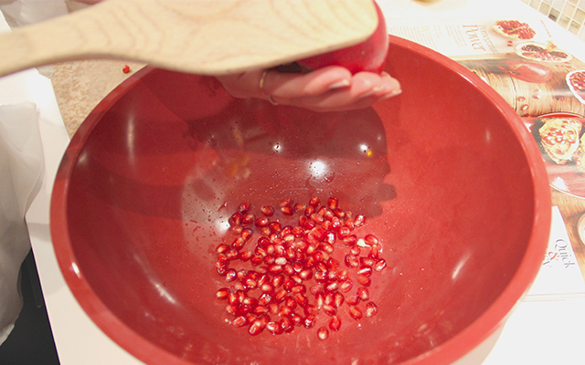 Deseeding a pomegranate over a bowl