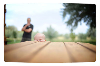 child peeking onto picnic table