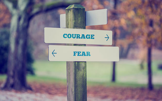 Sign in an autumn park with the words "Courage" and "Fear"