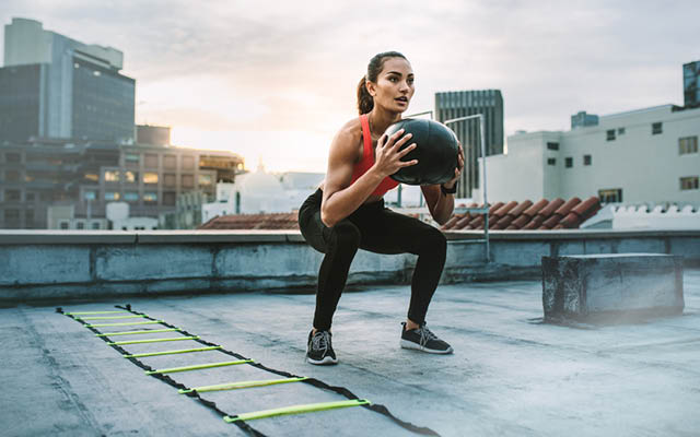 Woman with medicine ball doing a ladder workout