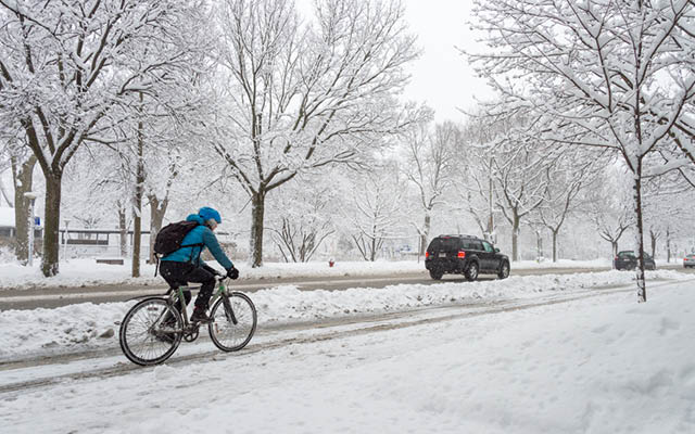 A person rides their bike in the winter.
