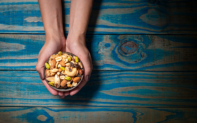 hands hold a bowl of nuts