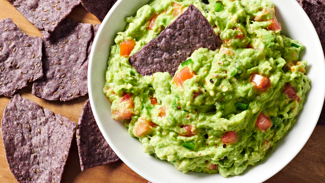 5-minute guacamole in a bowl with blue corn chips.