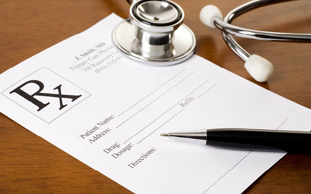 A prescription form with a stethoscope and a pen