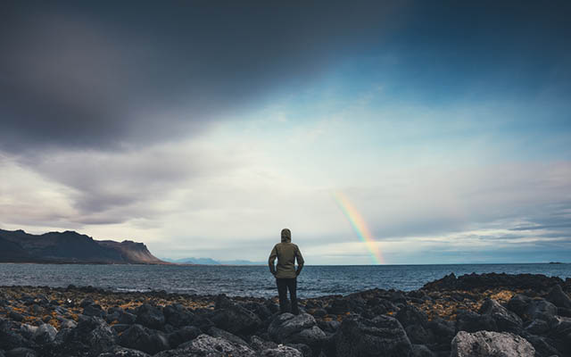 Woman watching rainbow over Icelandic landscape