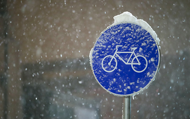 A snow-covered bike sign