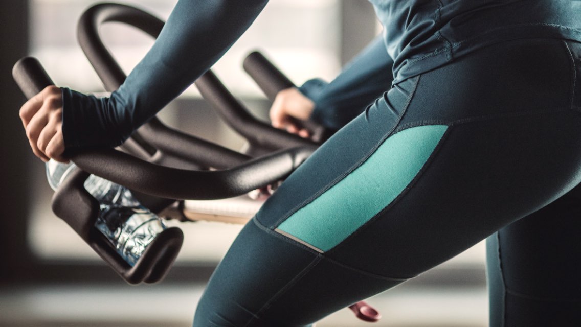 a close up of a woman riding an indoor cycle