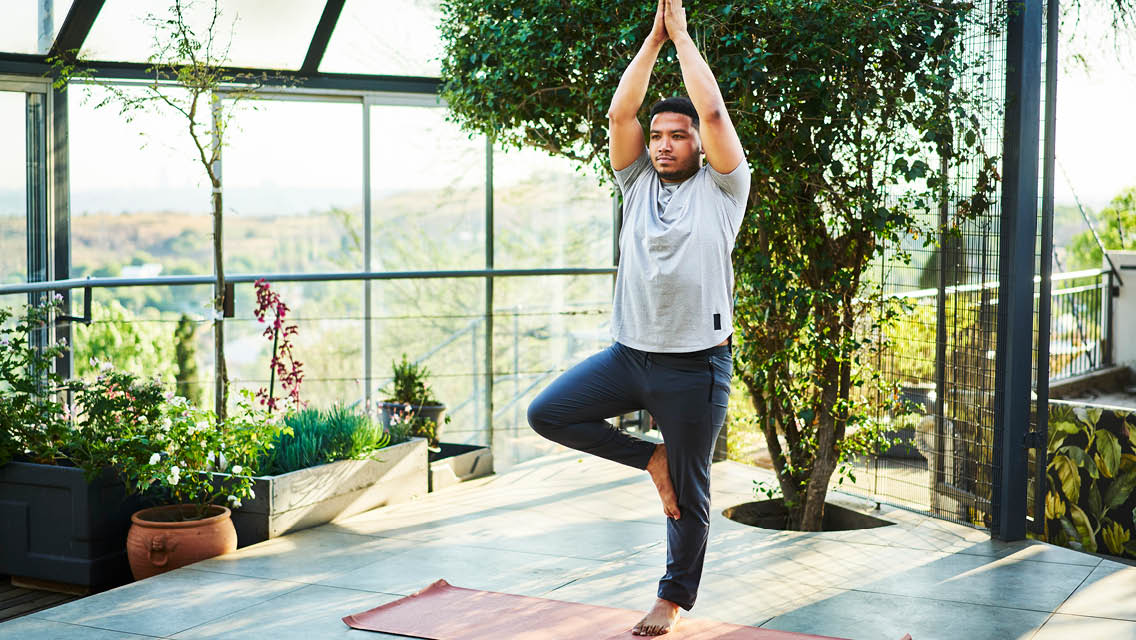 a man holds tree pose