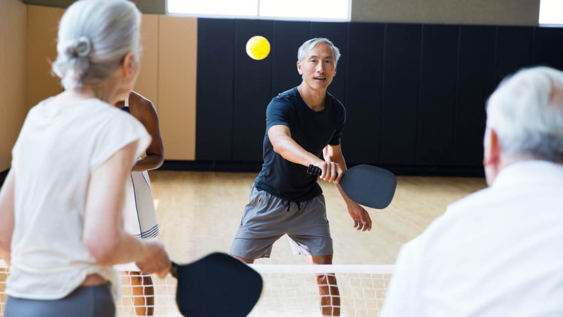 A group of four playing pickleball.