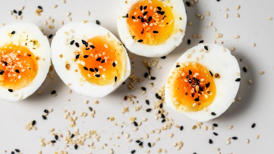 Four halves of hard-boiled eggs with seasoning sprinkled on the top of them.