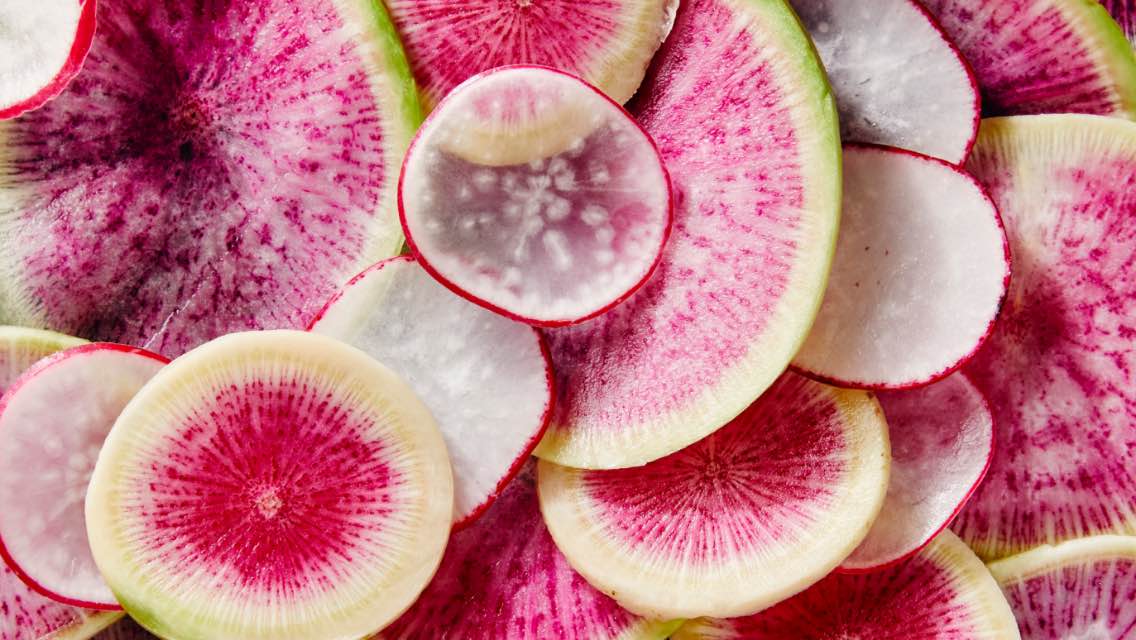 A close up image of a bunch of sliced radishes.