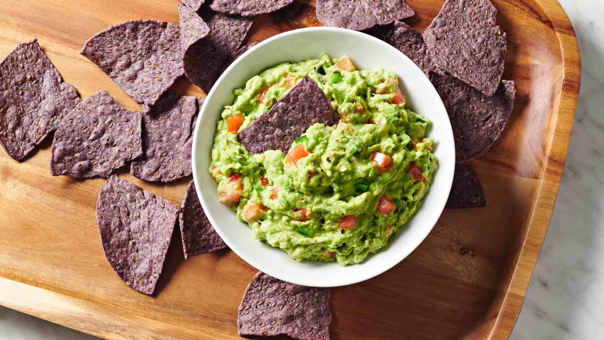 blue corn chips with a bowl of guacamole
