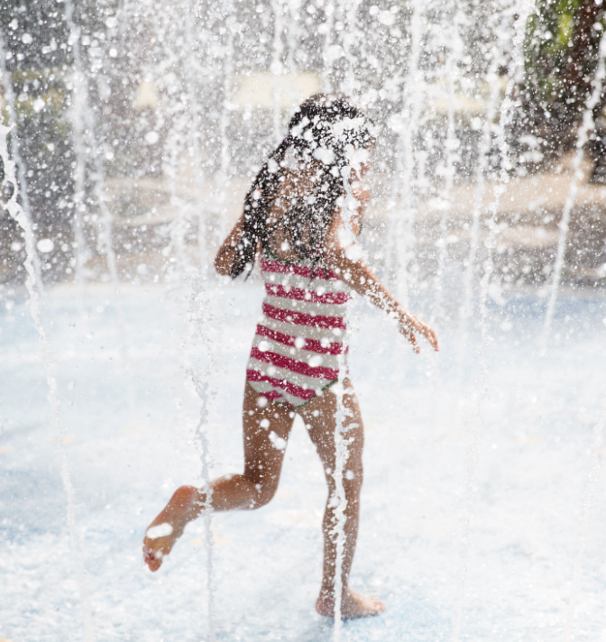 Young girl playing in a splash pad.