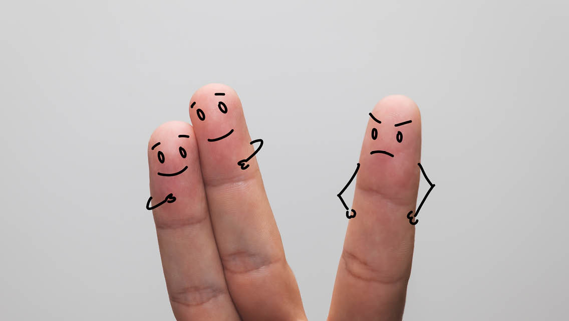 fingers with faces drawn: two side by side smiling, the third with a crabby face looking at the two happy fingers