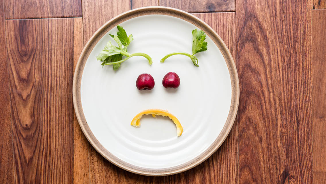 a plate with food made to look like a frowny face