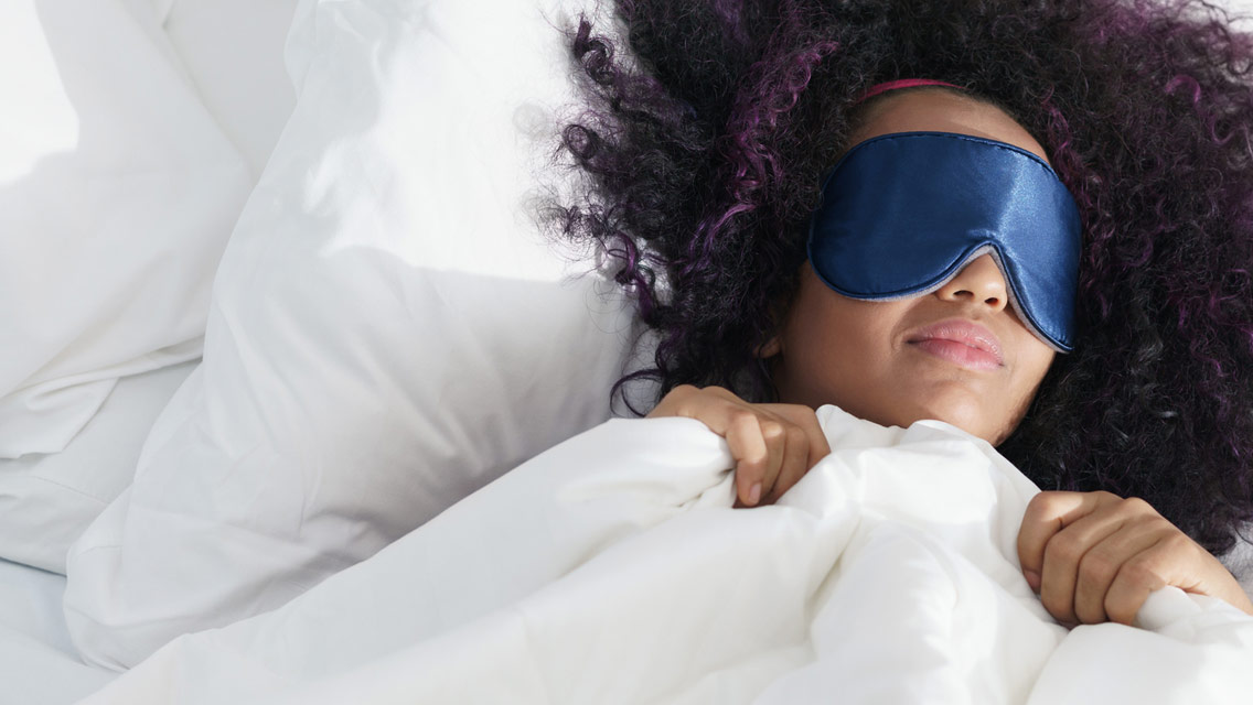 a woman sleeps with an eye mask