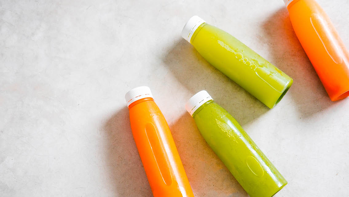 bottles of orange and green juice
