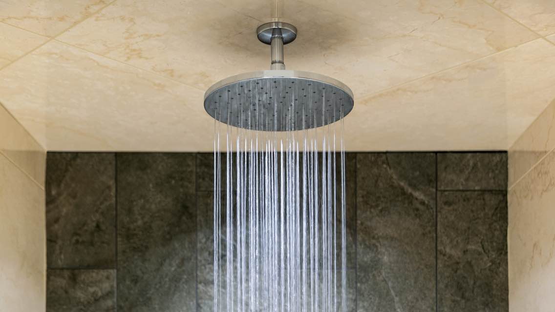 A showerhead turned on with water coming out.