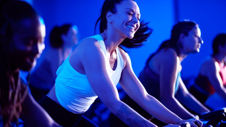 A woman in an indoor cycle class.
