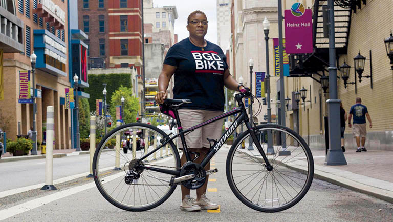 Monica Garrison standing on an urban road with a bike