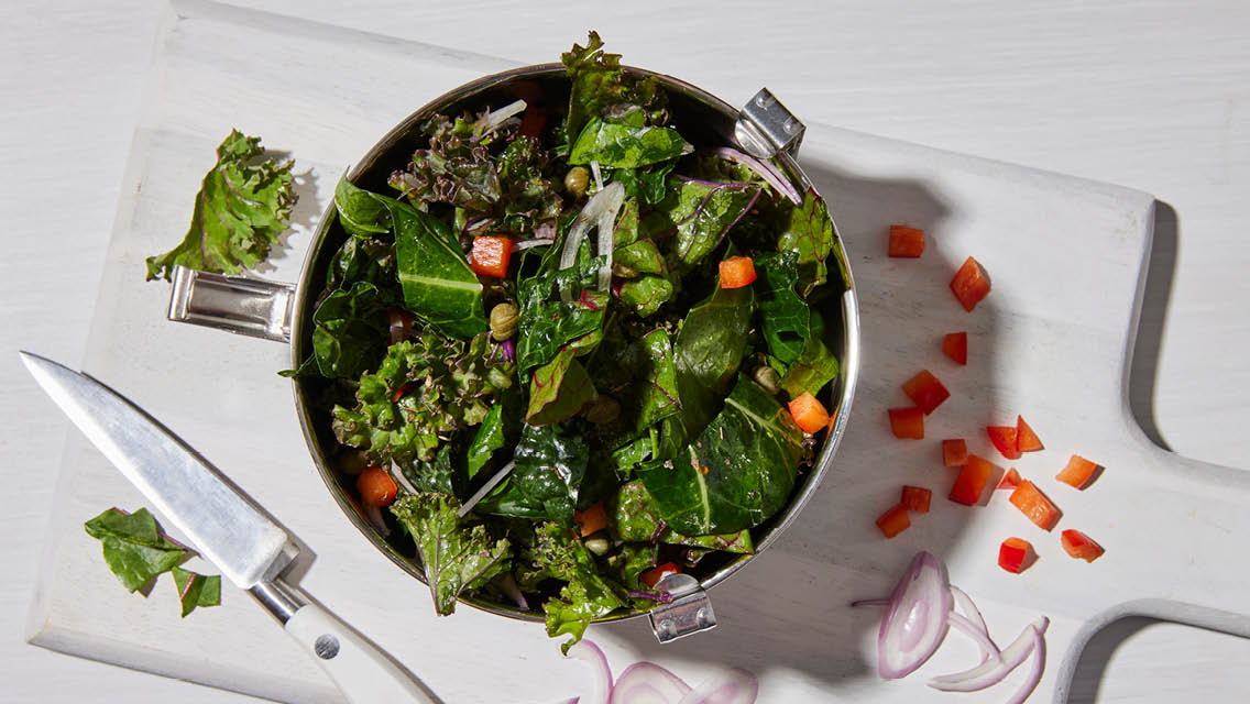 a sturdy green salad in a metal lunch box bowl