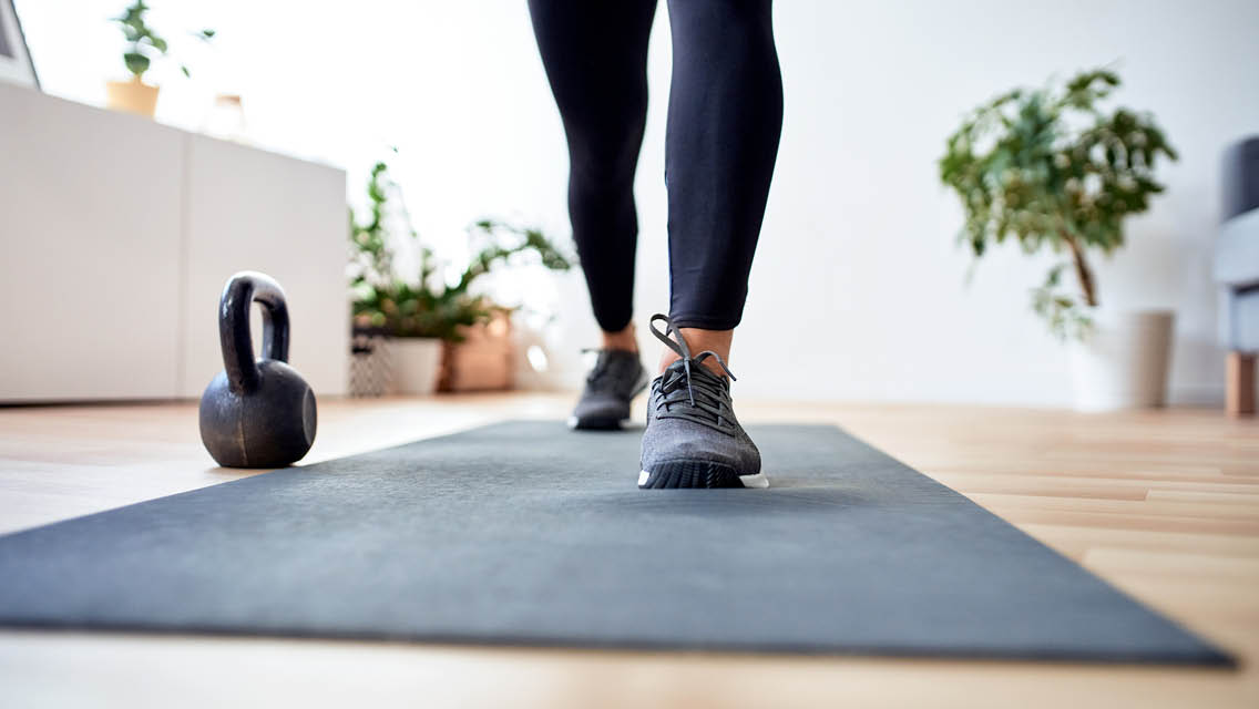 feet on a yoga mat with a kettlebell sitting next to it