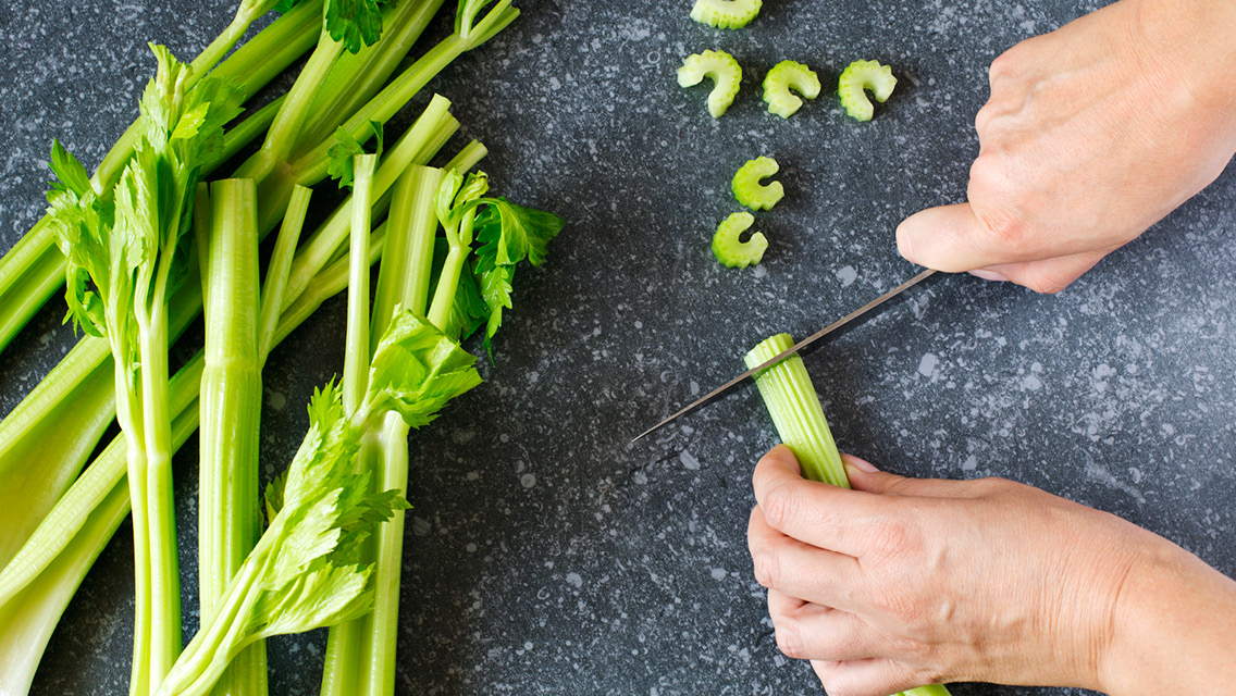 a person slicing celery