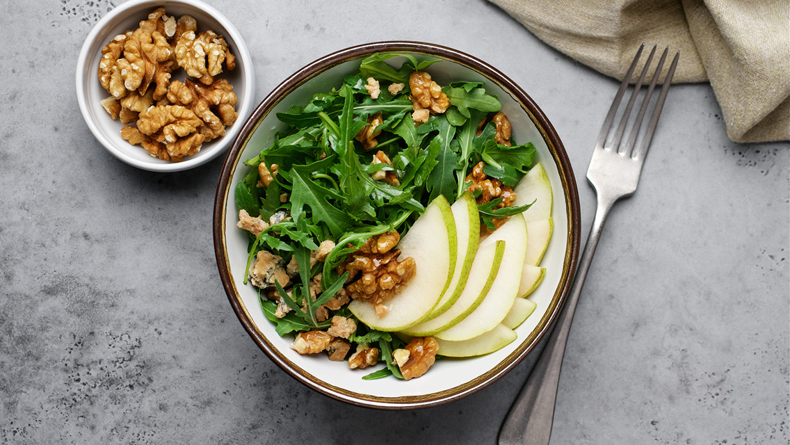 a salad topped with walnuts