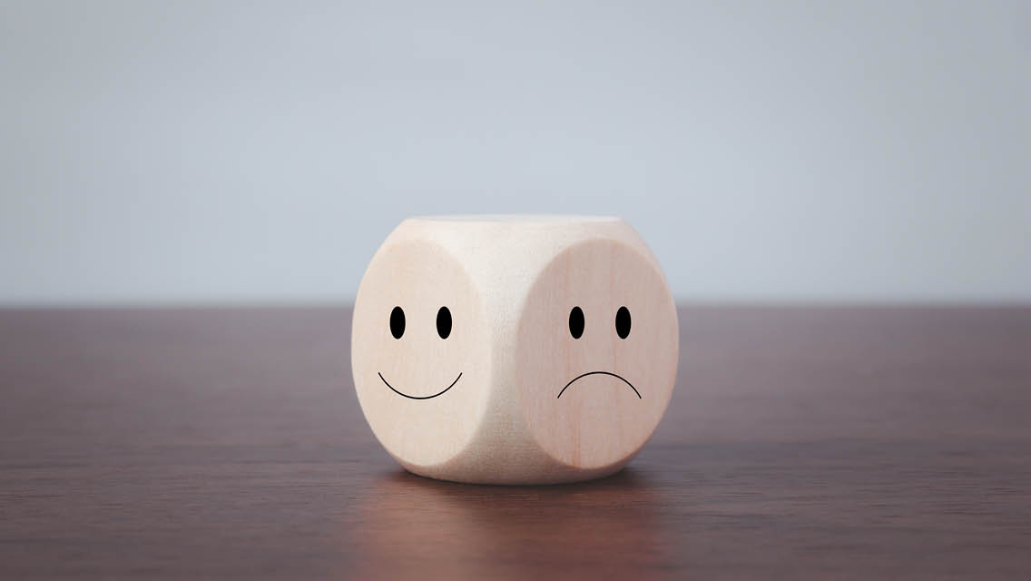 a dice with a happy face and sad face