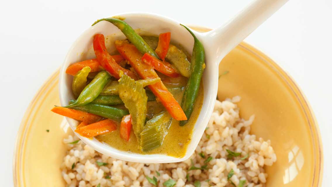 a spoon filled with curry vegetables