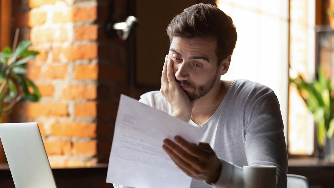a man looks at a letter in disbelief