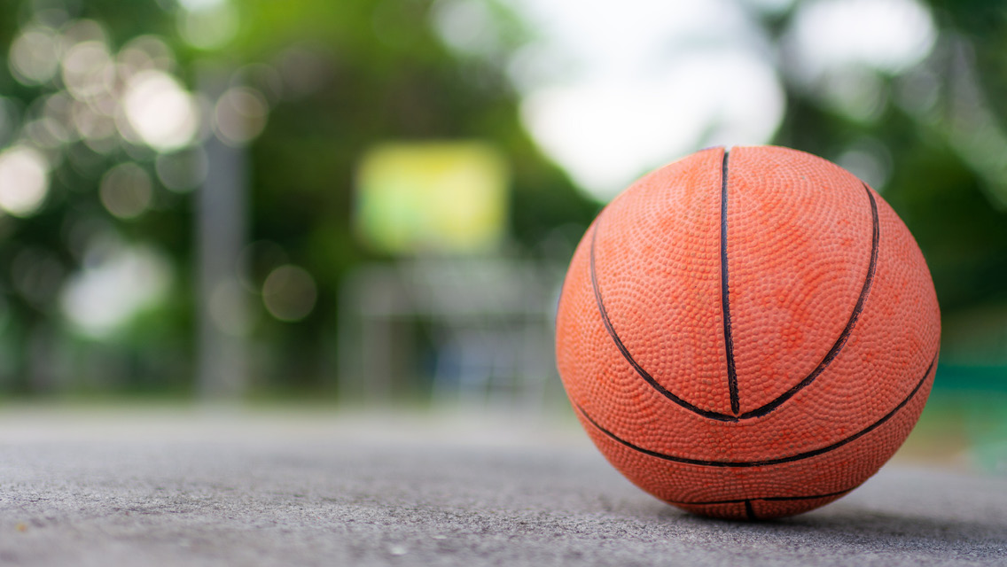 a basketball sits on a paved sidewalk