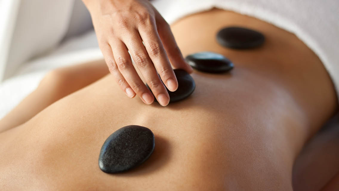 hot stones are placed on a person's back