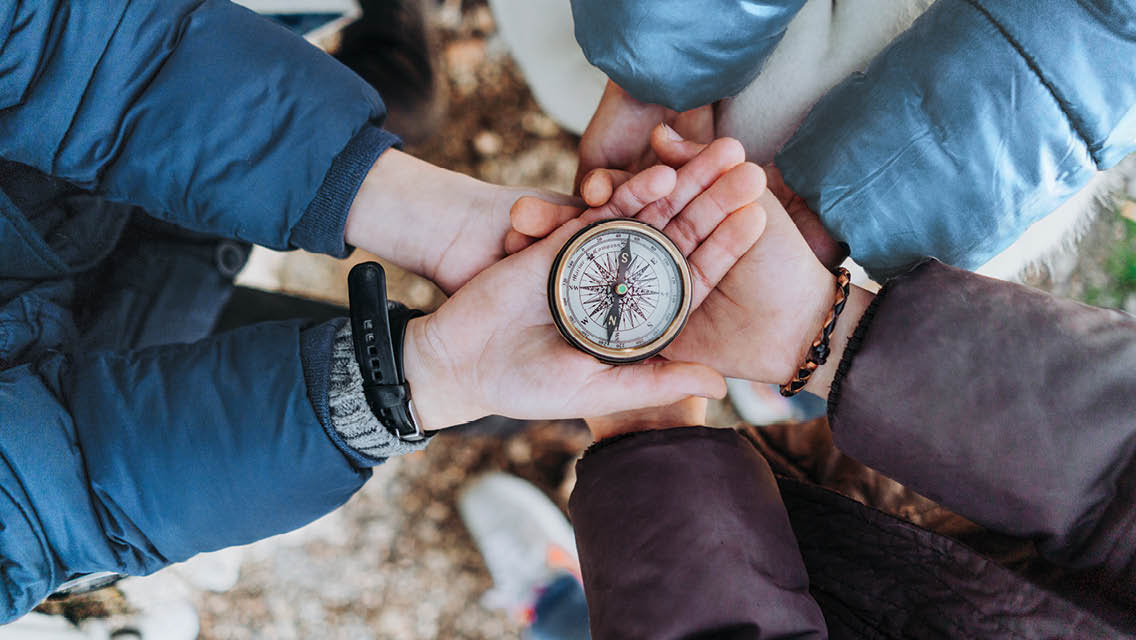 people holding a compass