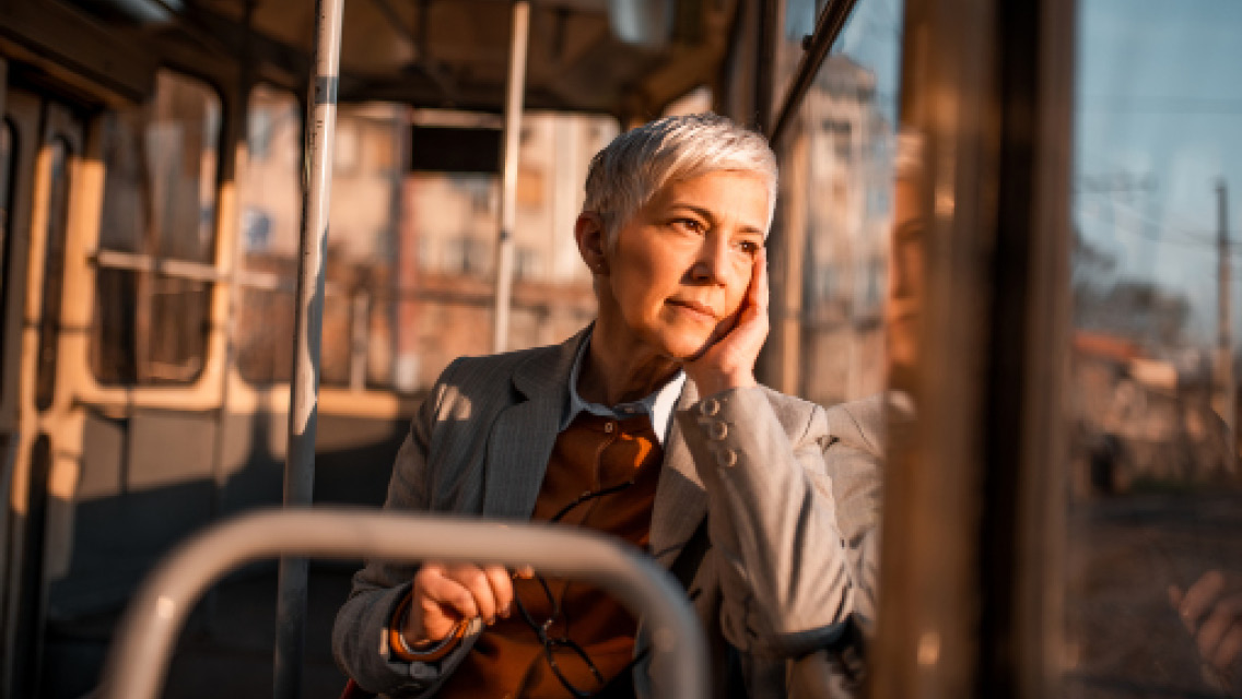 a woman rides a bus while looking forlornly out the window