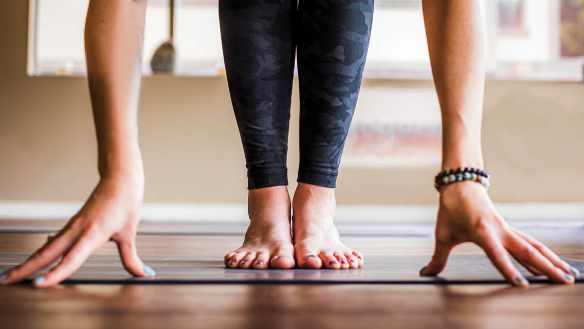 a person's feet and hands on a yoga mat