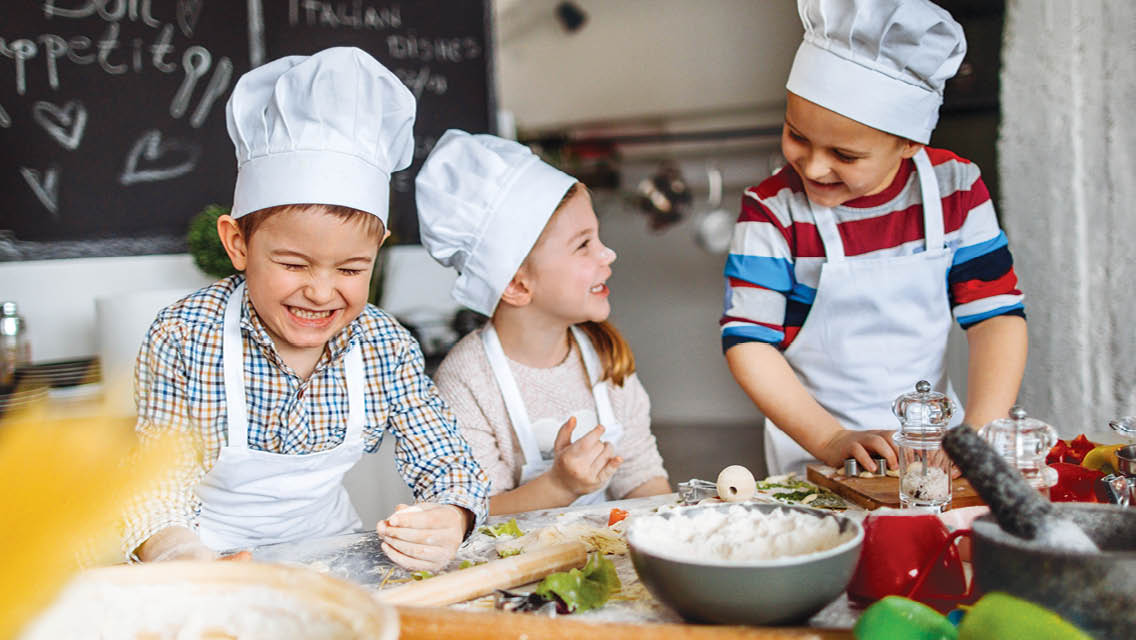 kids wearing chefs hats while cooking
