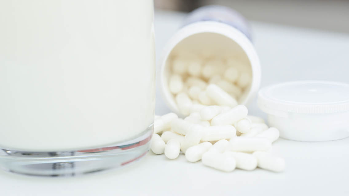 supplements next to a glass of milk