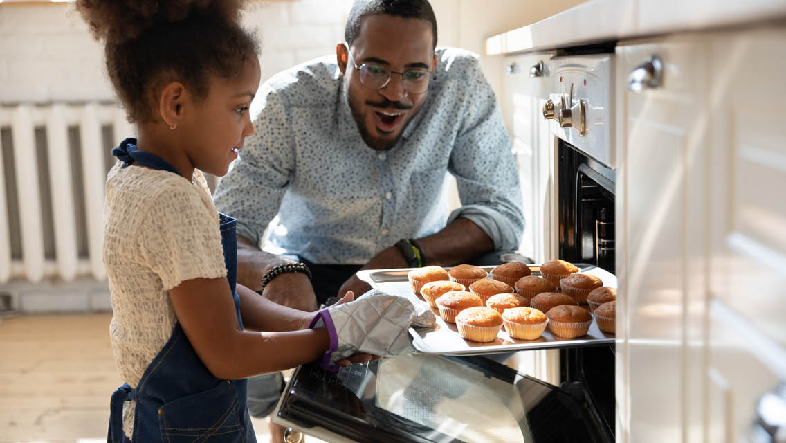 a father and daughter bake in the kitchen