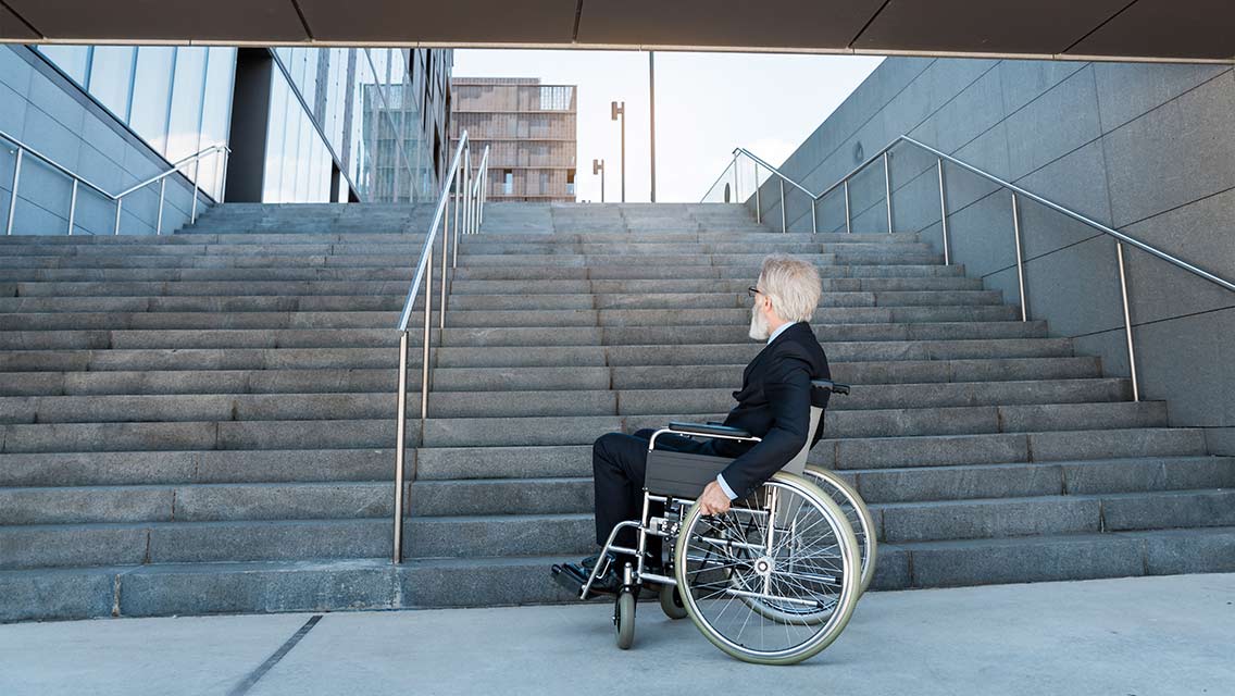 a man in a wheelchair looks at a flight of stairs