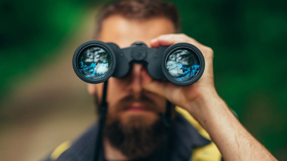 a man looks through binoculars
