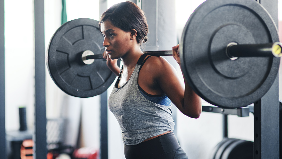 a woman prepares to squat with a heavy barbell